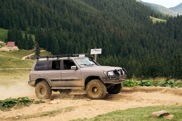 massive 4x4 off-road car on the dirty ground in mountains. Off-road expedition. Safari.