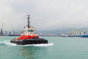 Towing boat. Tugboat Maneuvers, tugboat on maneuvers at sea.