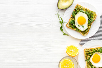 Open sandwich with eggs and avocado on plate. Overhead view
