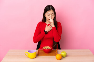 Young Chinese girl  having breakfast in a table coughing a lot