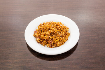 Fried rice recipe with wok beef and soy sauce cooked by a Chinese chef on dark wooden table