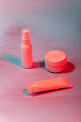 Fototapeta premium white bottles of cosmetics in neon