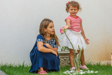 Criança mostra flor para amiga