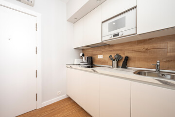 Small white American kitchen with small appliances above the counter of a vacation rental apartment