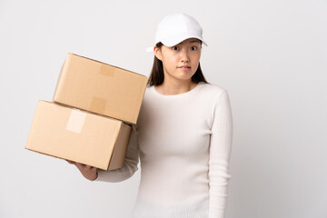 Young delivery Chinese woman over isolated white background having doubts and with confuse face expression