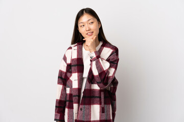 Young Chinese girl over isolated white background looking to the side and smiling