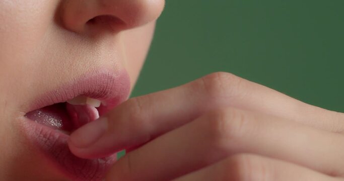 Young woman chewing gum on color background, closeup