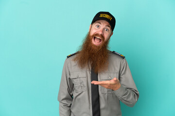 Redhead security man isolated on white background presenting an idea while looking smiling towards