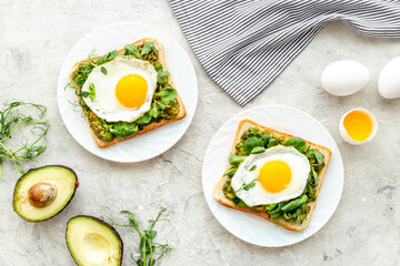 Breakfast with avocado toasts and fried eggs, top view