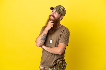 Redhead Military man with dog tag isolated on yellow background looking to the side