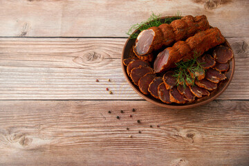 Homemade jerked dried meat or biltong with spices on a wooden background. Beer snack concept. Selective focus, copyspace.