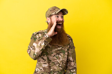 Military Redhead man over isolated on yellow background shouting with mouth wide open to the lateral
