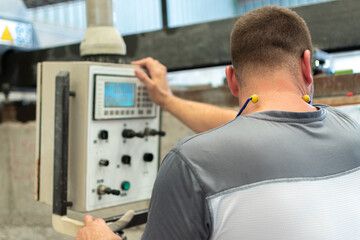 Caucasian man writing down values on computer at his workplace