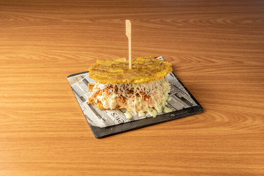 Super Venezuelan plantain patacon crushed with grated fresh cheese with pull chicken meat and sauces