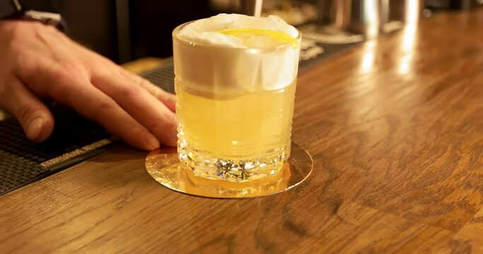 The bartender puts the finished cocktail on the bar and hands it over to the client. Bar.