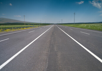 Fototapeta premium Straight asphalt road in the countryside
