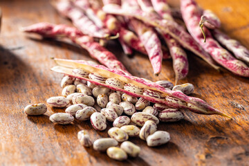 Cranberry beans. Borlotti beans. Beans pods on wooden table.
