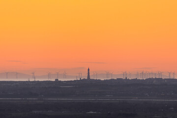 View over the Blackpool promenade from a distance showing the Blackpool Tower, Fylde Coast, wind turbines and the Isle of Man in the distance, UK