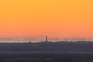 Obraz premium View over the Blackpool promenade from a distance showing the Blackpool Tower, Fylde Coast, wind turbines and the Isle of Man in the distance, UK