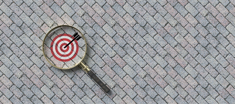 magnifier with a target symbol on stone pavement background
