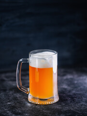 A mug of beer on a black wooden table