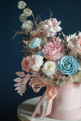 Beautiful flowers. Preserved roses with dried flowers bouquet closeup. Beautiful flower arrangement in a pink box.