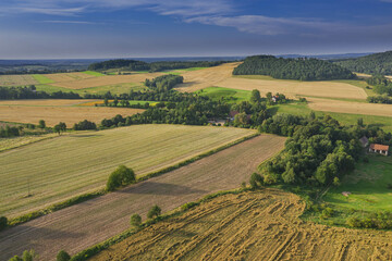 Sudeten foothills. Undulating terrain covered with arable fields, meadows, clumps of trees. In the...