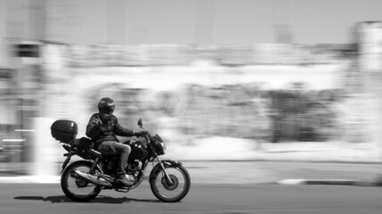 Fototapeta na wymiar hardworking biker waving at the camera while driving