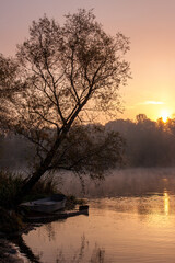 Autumn fog on river. Sunrise, reflection, boat.