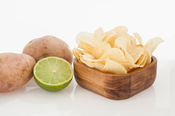 Wooden Bowl With Tasty Potato Chips Lemon Flavor; Photo On White Background