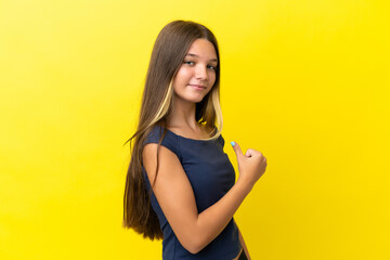 Little caucasian girl isolated on yellow background proud and self-satisfied