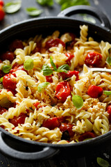 Feta pasta, pasta with sauce based on feta cheese, cherry tomatoes and herbs, close up view. A popular vegetarian dish.