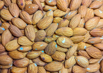 Background of big raw peeled almonds situated arbitrarily.Peeled almonds closeup. For vegetarians.