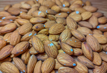 Background of big raw peeled almonds situated arbitrarily.Peeled almonds closeup. For vegetarians.