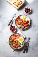 English breakfast with fried eggs, bacon, sausages, beans, toasts on white background