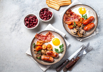 English breakfast with fried eggs, bacon, sausages, beans, toasts on white background