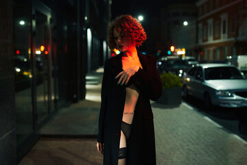 Obraz premium The cloaked Lead walks around the city at night. Shooting in the style of cinema