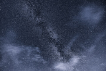milky way on a partly cloudy sky in monochrome