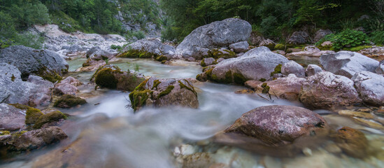 Naklejka na ściany i meble Long exposure of mountain river soca near its spring with clear water in the morning, Slovenia