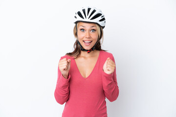 Young Russian woman wearing a bike helmet isolated on white background celebrating a victory in winner position