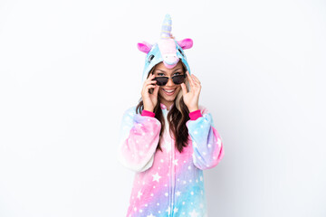 Young Russian woman wearing a unicorn pajama isolated on white background with glasses and surprised
