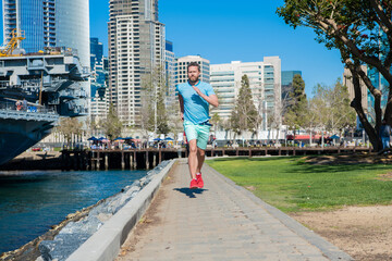 Naklejka premium My run my speed. Energetic man run on promenade. Male runner in sportswear. Running exercises