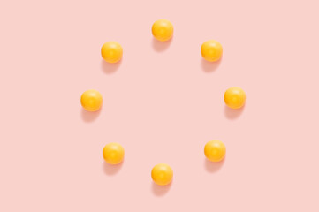 Circle of yellow grapefruits on the pastel pink background. Minimal flat lay composition.