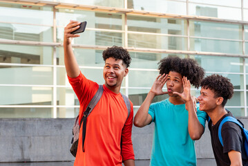 Multiethnic friends taking selfie in the street