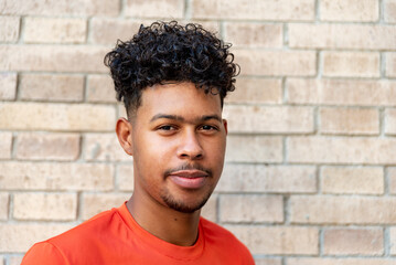 Portrait of young afro latin man against a wall