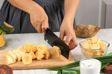 Slicing Banana, Preparation making Banana and Sweet Potato Compote (Kolak Pisang Ubi). Ripe Banana, Sweet Potato, Palm Sugar, Pandan Leaves, and Coconut Milk. 