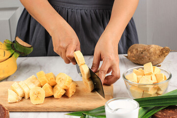 Slicing Banana, Preparation making Banana Sweet Potato Compote (Kolak Pisang Ubi). Ripe Banana, Sweet Potato, Palm Sugar (Gula Merah), Pandan Leaves,  Coconut Milk. Popular for Ramadan Breakfasting