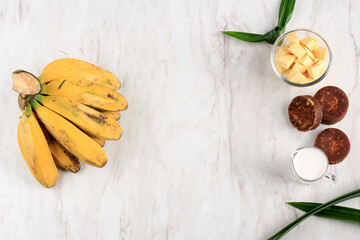 Top View Ingredient Preparation making Banana and Sweet Potato Compote (Kolak Pisang Ubi). Ripe Banana, Sweet Potato, Palm Sugar (Gula Merah), Pandan Leaves, and Coconut Milk. Popular for Ramadan