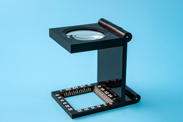 Quality control and printing industry inspection tools concept with linen test magnifier lens tool isolated on blue background