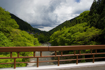 River runs through a forest and mountain valley in Japan.